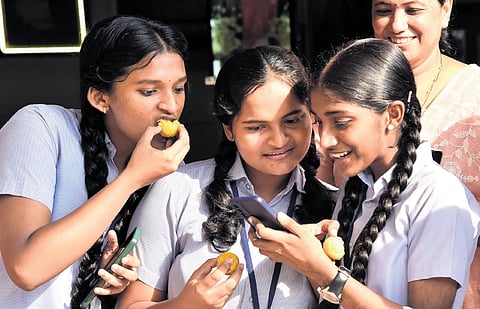 Students of St Antony’s Higher Secondary School celebrate their SSLC examination results by sharing sweets