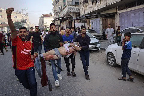 Palestinians transport an injured man pulled from the rubble of a house destroyed in an Israeli strike in the center of Rafah in the southern Gaza Strip on May 5, 2024