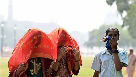 Women cover themselves with scarves on a hot summer day in Delhi.