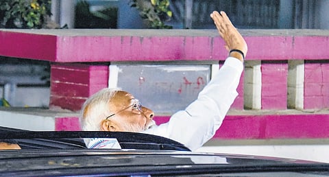 Prime Minister Narendra Modi waves at supporters during a visit to former Bihar Deputy CM Sushil Kumar Modi’s residence in Patna on Monday.