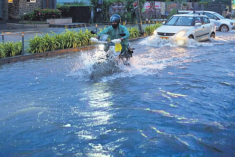 Motorists wading through the inundated Stadium Link Road in Kochi on Wednesday