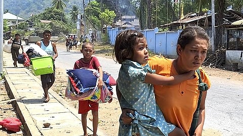 In this photo released by the Free Burma Rangers, families flee after a Buddhist monastery sheltering civilians displaced by fighting in the town of Papun, Karen state, Myanmar, was attacked on March 31, 2024, by a regime warplane.