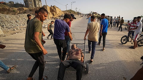 Palestinians carry the body of a man after he was shot by Israeli army tanks in central Gaza Strip, Saturday, May 18, 2024.