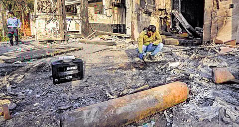 Forensic experts collect samples from the site of the fire accident