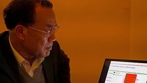 Zhang Yongzhen, the first scientist to publish a sequence of the COVID-19 virus, looks at a presentation on his laptop in a coffeeshop in Shanghai, China.
