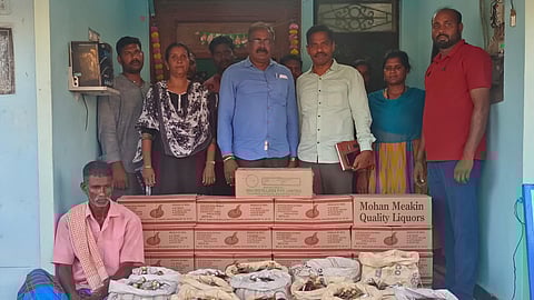 Villupuram Prohibition Enforcement Wing personnel with the arrested individual and seized liquor bottles near Brammadesam