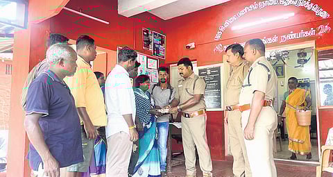 Valparai forest range officer G Venkatesh handing over compensation of Rs50,000 to the wife of the deceased at Valparai on Thursday