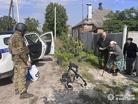 Police evacuate elderly people following the Russian attack around the town of Vovchansk in Kharkiv region, Ukraine, Friday, May 10, 2024.