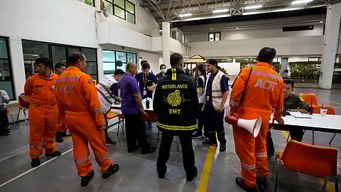 Members of a rescue team discuss after a London-Singapore flight was diverted to Bangkok due to severe turbulence, in Bangkok, Thailand.