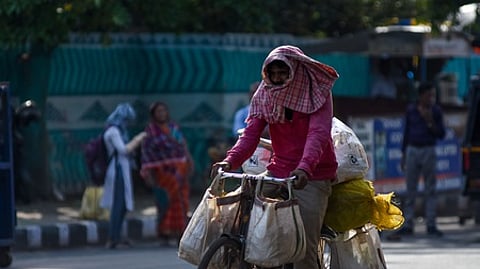 A man riding a cycle seen covering his head with a towel near Unit 1 Market in Bhubaneswar on Thursday.