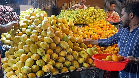 A customer seen purchasing mangoes at a fruit stall