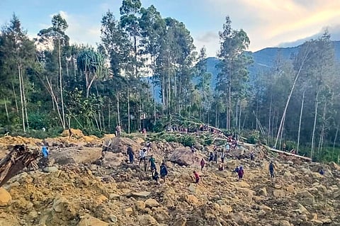 People gather at the site of a landslide in Maip Mulitaka in Papua New Guinea's Enga Province on May 24, 2024.