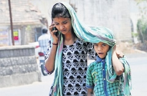 People cover themselves from the sun with a stole in Karimnagar on Friday