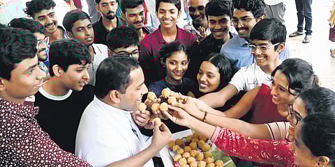 Fr Xavier Ambat, principal, Christ Nagar Central School, Kowdiar, distributes sweets to the students following exemplary results in Class X and XII CBSE examination