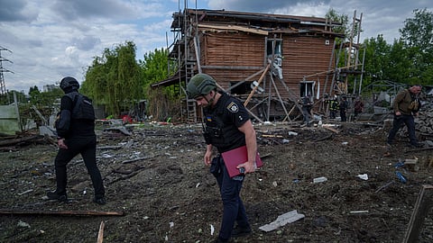 Ukrainian police officers look for fragments of a glide bomb in front of damaged house after a Russian airstrike on a residential neighbourhood in Kharkiv, Ukraine.