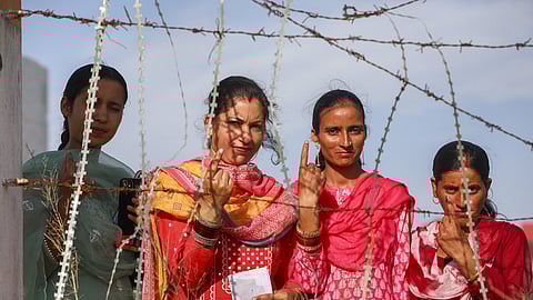 People show their inked fingers after casting their votes during Lok Sabha elections.