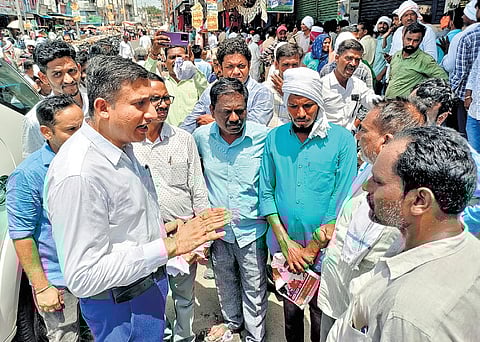 Warangal District Collector interacts with farmers after inspecting the fertiliser shops in Warangal on Wednesday
