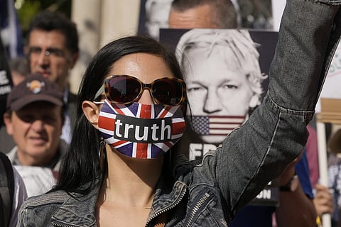 A protester stands outside the High Court in London, Monday, May 20, 2024.