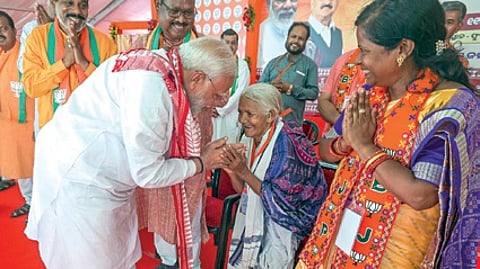 PM Narendra Modi takes the blessings of Padma Shri Purnamasi Jani during his election rally in Phulbani on Saturday