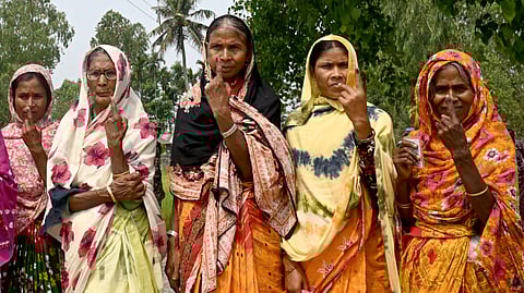 Women show their inked fingers after casting their ballots to vote in the first phase of India's general election outside a polling station in Cooch Behar on April 19, 2024.
