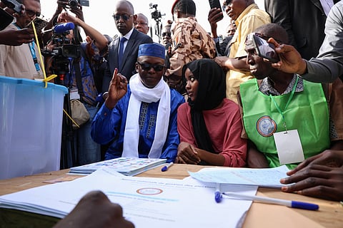Chad's transitional Prime Minister and Les Transformateurs party presidential candidate Succes Masra (C) shows his finger dipped in indelible ink as he votes on May 6, 2024 during Chad's presidential election.