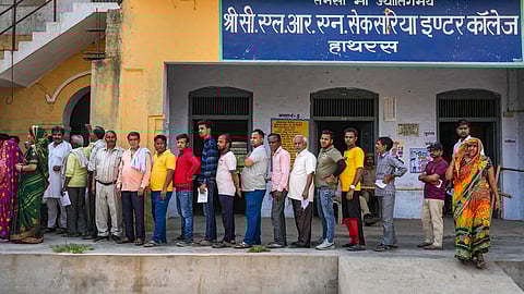 People wait in a queue to cast their vote for the third phase of Lok Sabha elections, in Hathras, Uttar Pradesh