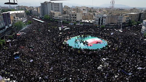 Iranians attend a funeral ceremony for the late President Ebrahim Raisi and his companions who were killed during a helicopter crash on Sunday in a mountainous region of the country's northwest, in Tehran, Iran, Wednesday, May 22, 2024.