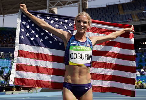 United States' Emma Coburn celebrates with the U.S. flag after winning the bronze in the women's 3000-meter steeplechase final during the athletics competitions in the Olympic stadium of the 2016 Summer Olympics in Rio de Janeiro, Brazil, on Aug. 15, 2016.