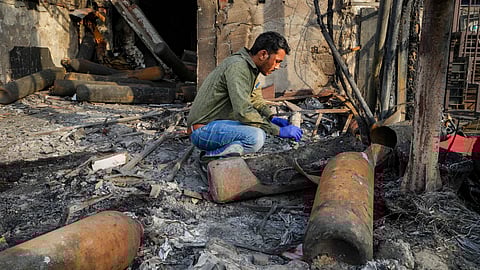 A forensic expert collects samples from the site of the fire at the Baby Care Hospital, in east Delhi, Sunday, May 26, 2024.