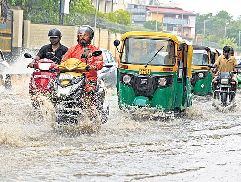 Motorists struggle to drive through the flooded Suranjan Das road in Bengaluru on Sunday