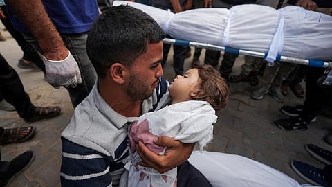 Karam Harara holds the body of his 2-year-old daughter Sabreen, who was among 20 people, mostly women and children, killed in an Israeli airstrike in central Gaza, before her funeral at the Al-Aqsa Martyrs Hospital in Deir al Balah, Gaza Strip.