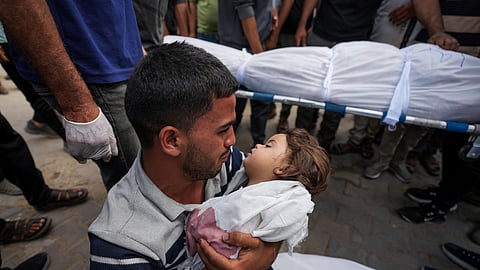 A Palestinian man holds the body of his 2-year-old daughter Sabreen killed in an Israeli airstrike in central Gaza.