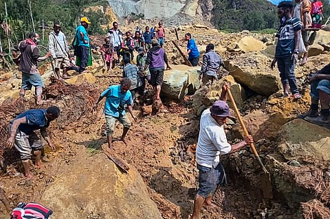 Villagers search through a landslide in Yambali, in the Highlands of Papua New Guinea, Sunday, May 26, 2024.