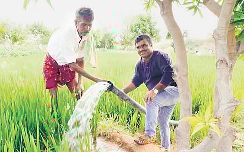 Sikandar Meeranayak, with a farmer, who uses the recharged borewell to water his farm