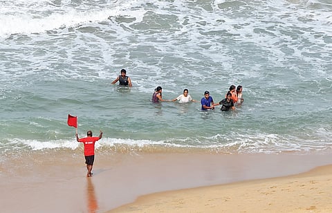 A lifeguard waving a red flag at swimmers who ventured into the sea on Papanasam Beach in Varkala on Friday.