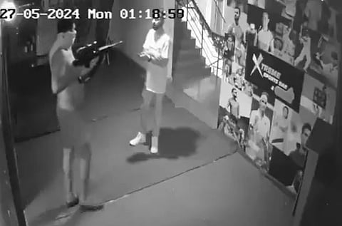 A screengrab from the CCTV footage shows the accused pointing a rifle at the victim.