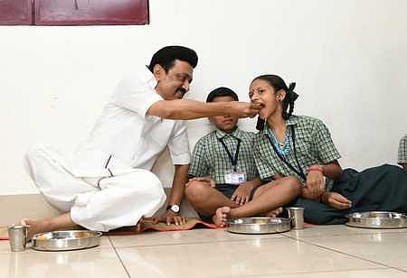 Chief Minister MK Stalin feeds a child during the launch of the breakfast scheme in Coimbatore