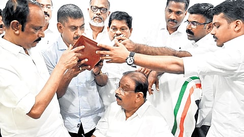 Congress leaders take a look at the register that was signed by K Sudhakaran after he took charge as state president of the party at Indira Bhavan in Thiruvananthapuram on Wednesday