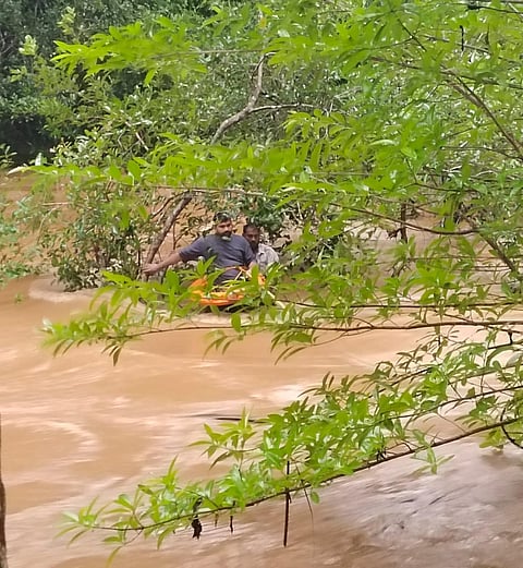 Fire officials rescuing two passengers from the river