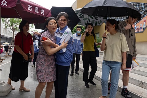 A student gets a hug from her teacher before attending the annual national college entrance exam also known as Gaokao.