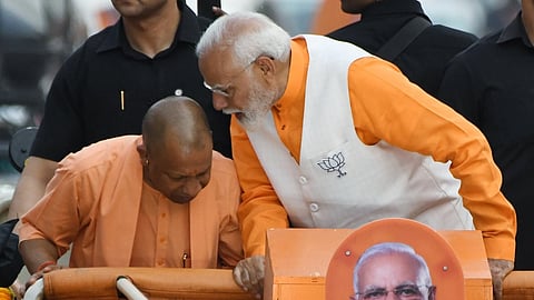 Uttar Pradesh Chief Minister Yogi Adityanath along with Prime Minister Narendra Modi during a roadshow for the Lok Sabha elections, in Varanasi.