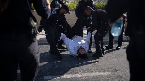 Israeli police officers remove an ultra-Orthodox Jewish man from the street during a protest against army recruitment in Jerusalem on June 2, 2024.
