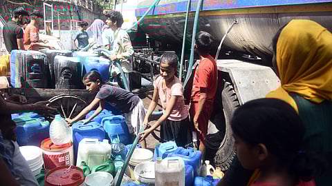 People are filling water in plastic drums from a municipality tanker during a high temperature heat wave, in New Delhi.