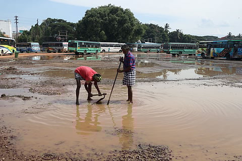 Workers clearing water stagnation in the temporary bus stand in Puducherry.