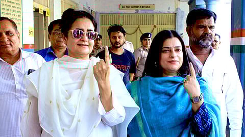 Kiran Chaudhary (L) and her daughter Shruti Chaudhary (R) pose after casting their votes during the 2024 Lok Sabha elections in Haryana