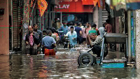 People wade through a waterlogged road near Sarai Kale Khan area after rain, in New Delhi, Friday, June 28, 2024.