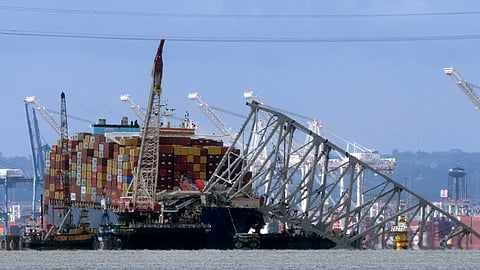FILE - The collapsed Francis Scott Key Bridge rests on the container ship Dali, May 12, 2024, in Baltimore, as seen from Riviera Beach, Md.