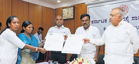 Transport Minister Ramalinga Reddy hands over compensation to the kin of a KSRTC employee who died in a road accident while on duty, on Wednesday