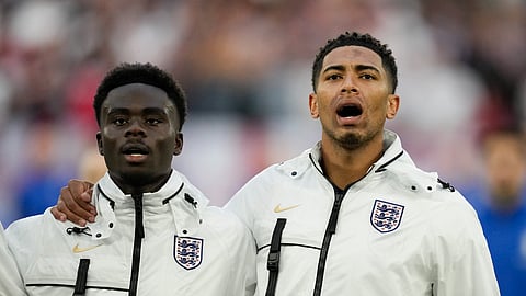 England's Bukayo Saka, left, and Jude Bellingham sing their national anthem before a Group C match between Serbia and England at the Euro 2024 soccer tournament in Gelsenkirchen, Germany, Monday, June 17, 2024.