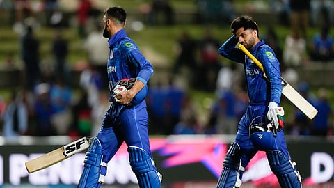 Afghanistan's Naveen-ul-Haq an teammate Fazalhaq Farooqi walk from the field after they were dismissed for 56 runs during the men's T20 World Cup semifinal cricket match between Afghanistan and South Africa